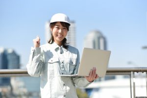 PCと作業服の女性