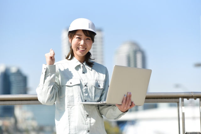 PCと作業服の女性